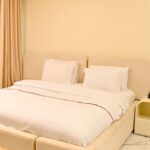 Traveler using a laptop to bypass Lagos shortlet agents and book Proof Residence directly.